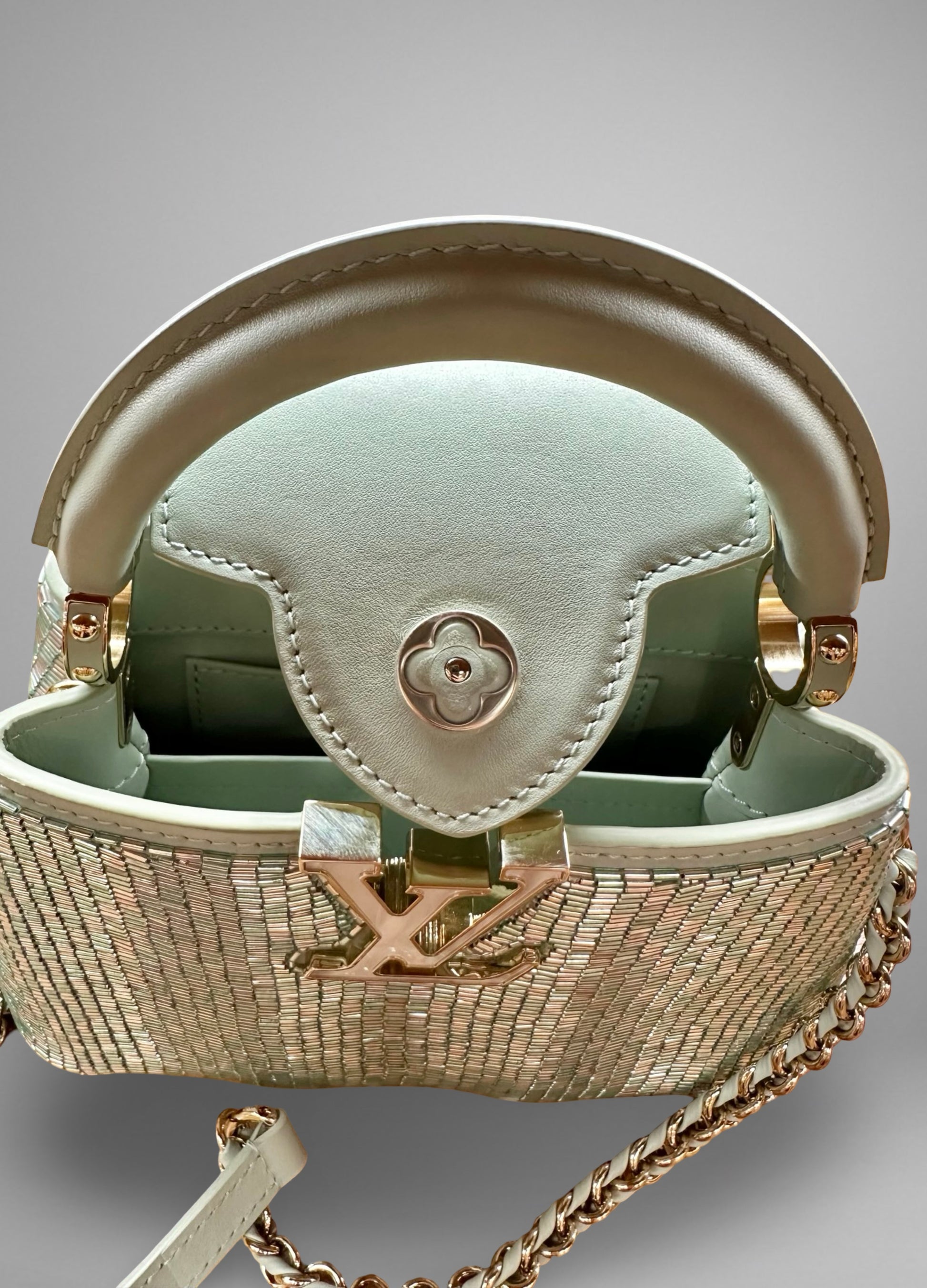 Designer handbag with chain detail on a gray background