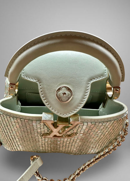 Designer handbag with chain detail on a gray background