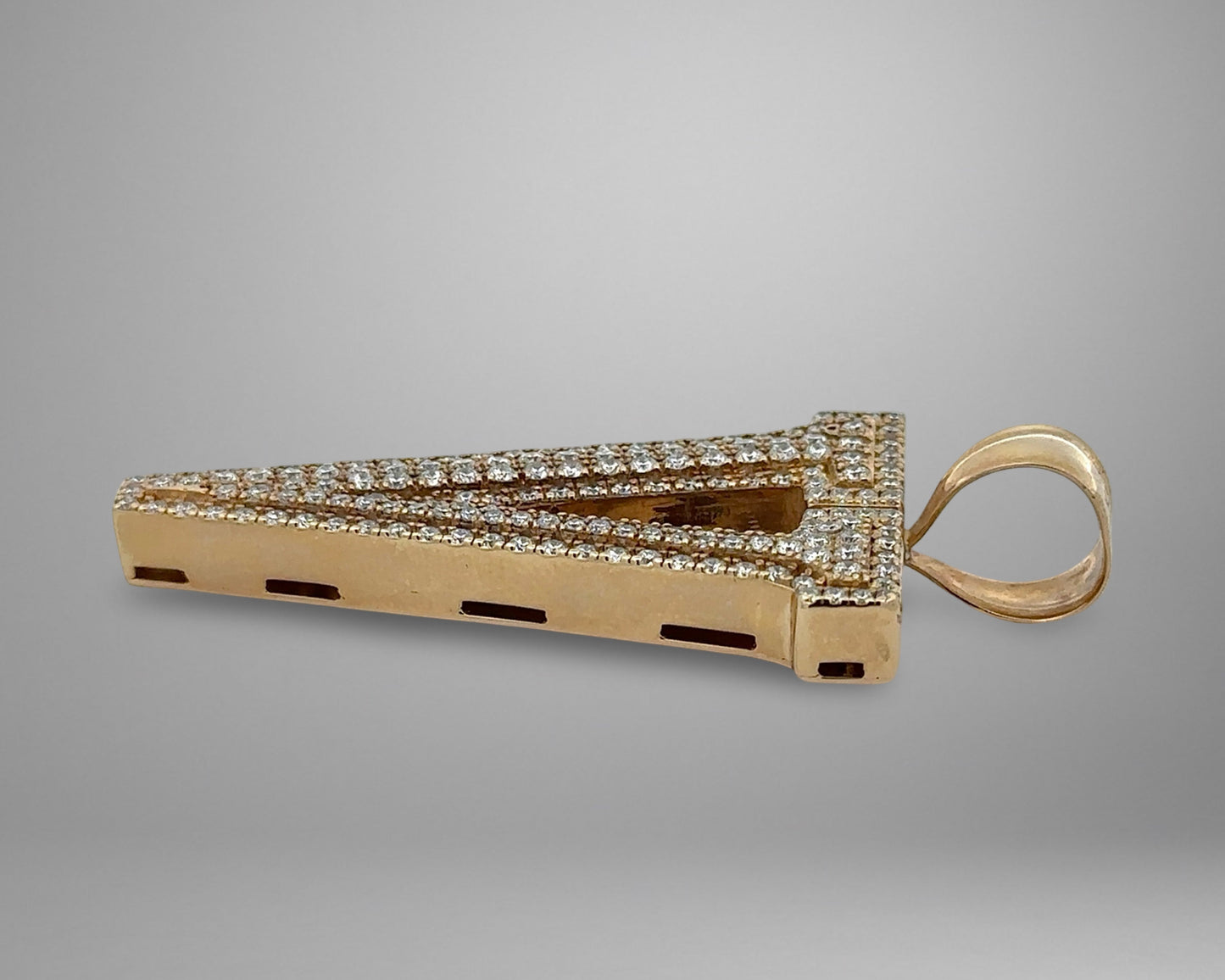 Gold and diamond-studded pendant on a gray background