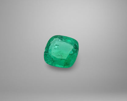 Cushion-shaped emerald on a gray background