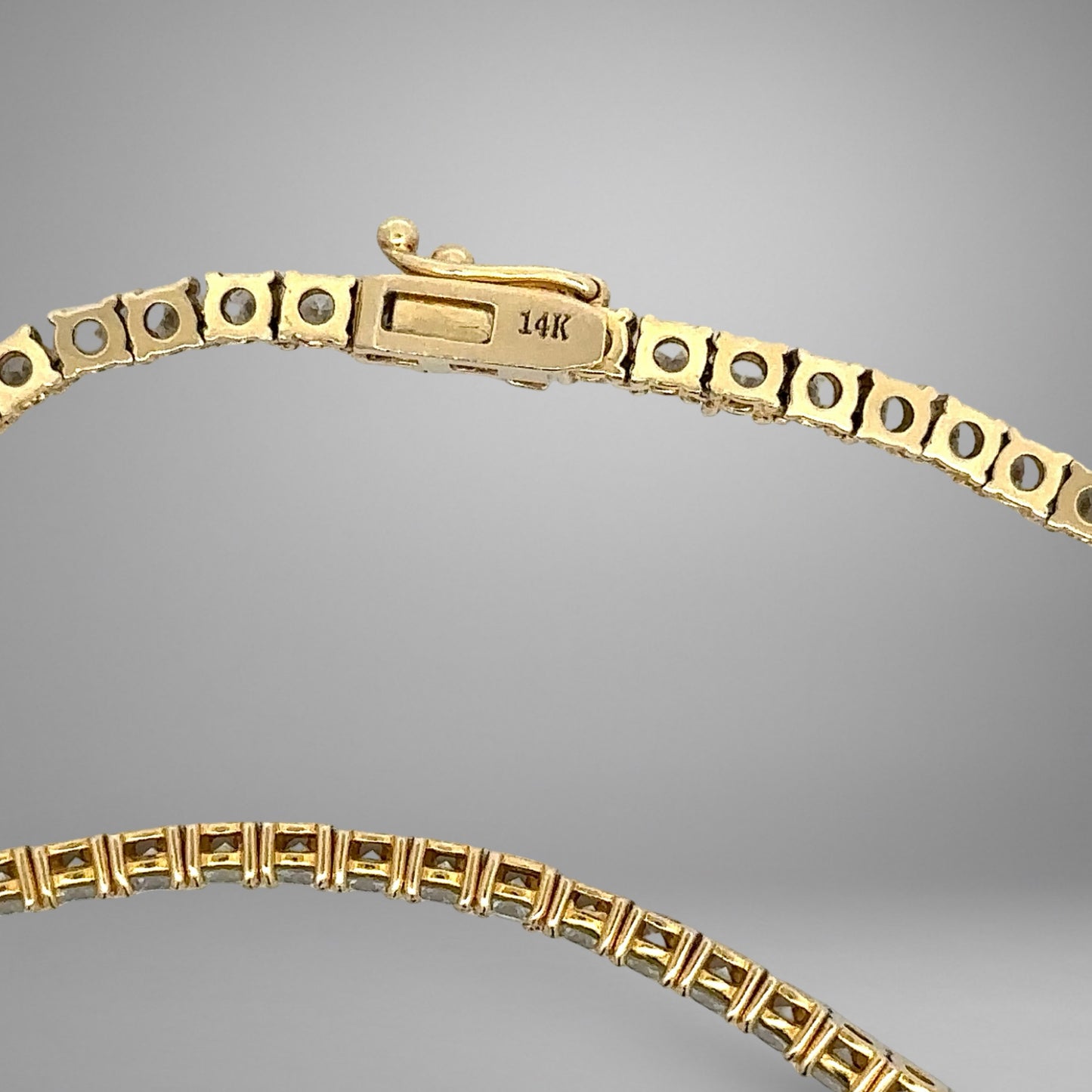 Gold necklace with a 14K box clasp on a gray background