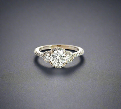 Front of white gold ring with 3 round diamond center stones, diamonds on the outline, and diamonds on the band