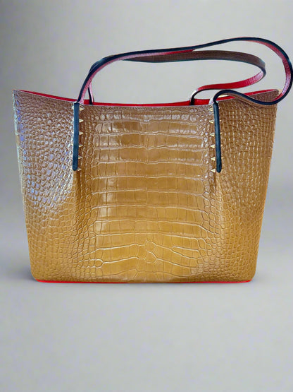 Front of brown tote bag with crocodile-like detailing and gold spike detailing. Shoulder straps are out of shape.
