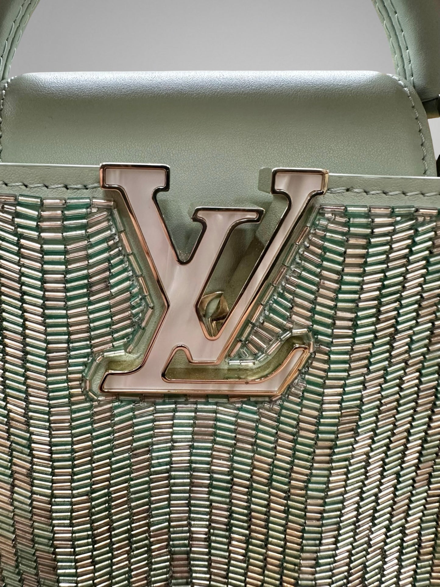 Close-up of a handbag with a prominent logo on a light background