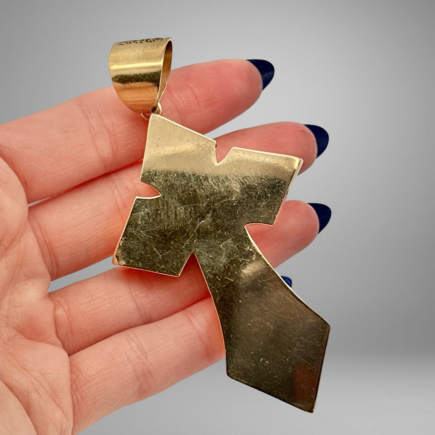 Back of yellow gold cross with scratches