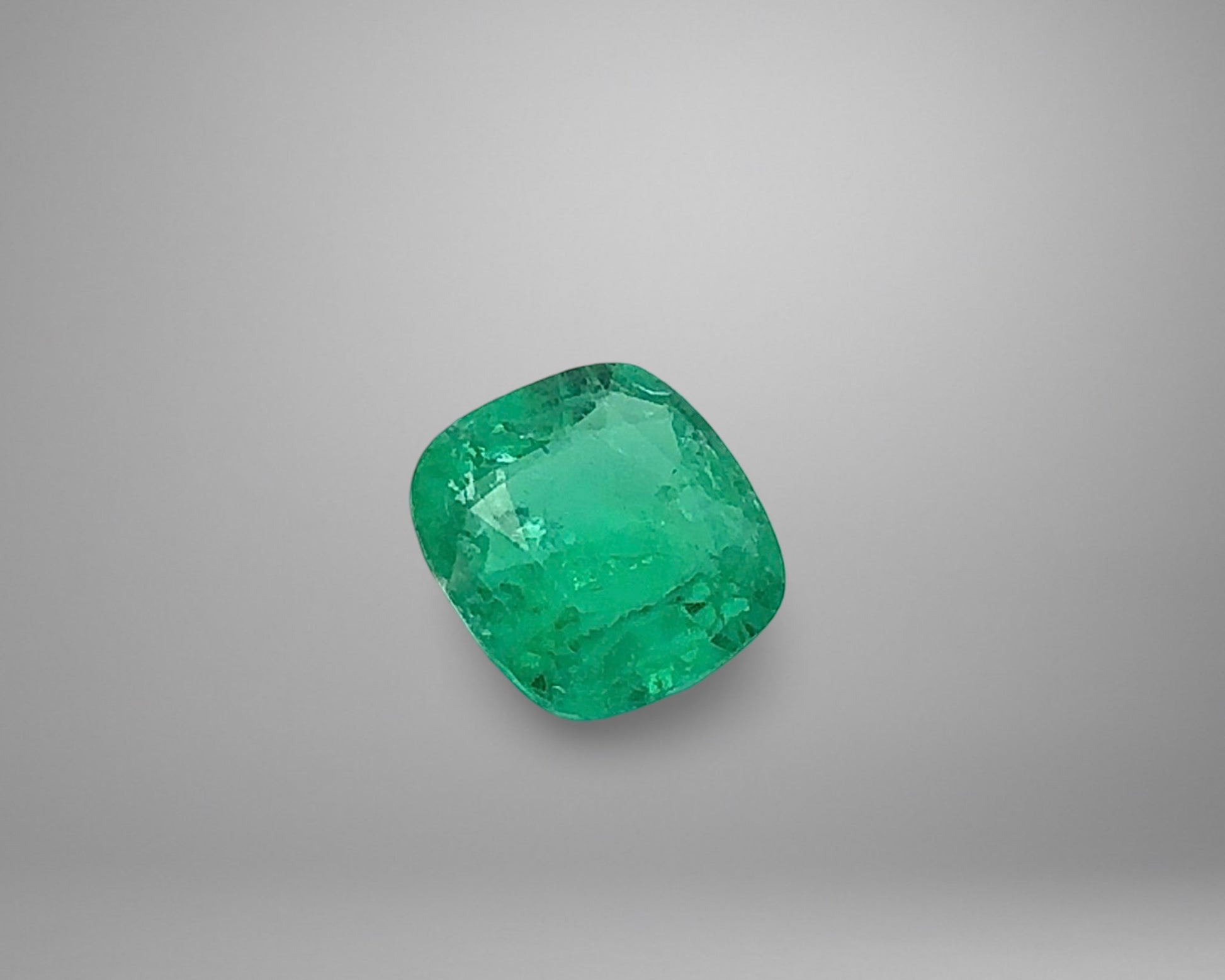 Green emerald gemstone on a gray background