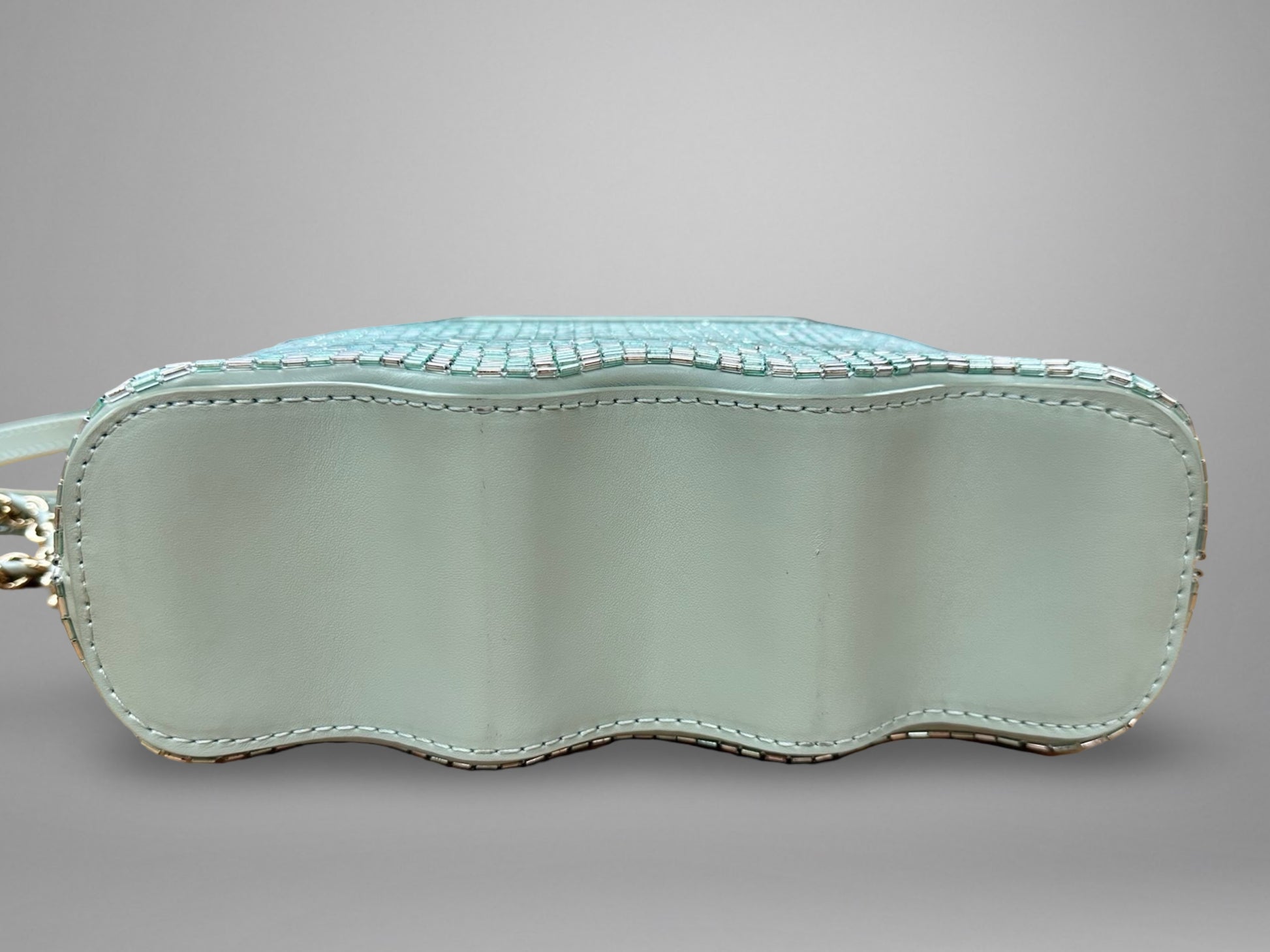 Light blue handbag with textured surface on a gray background