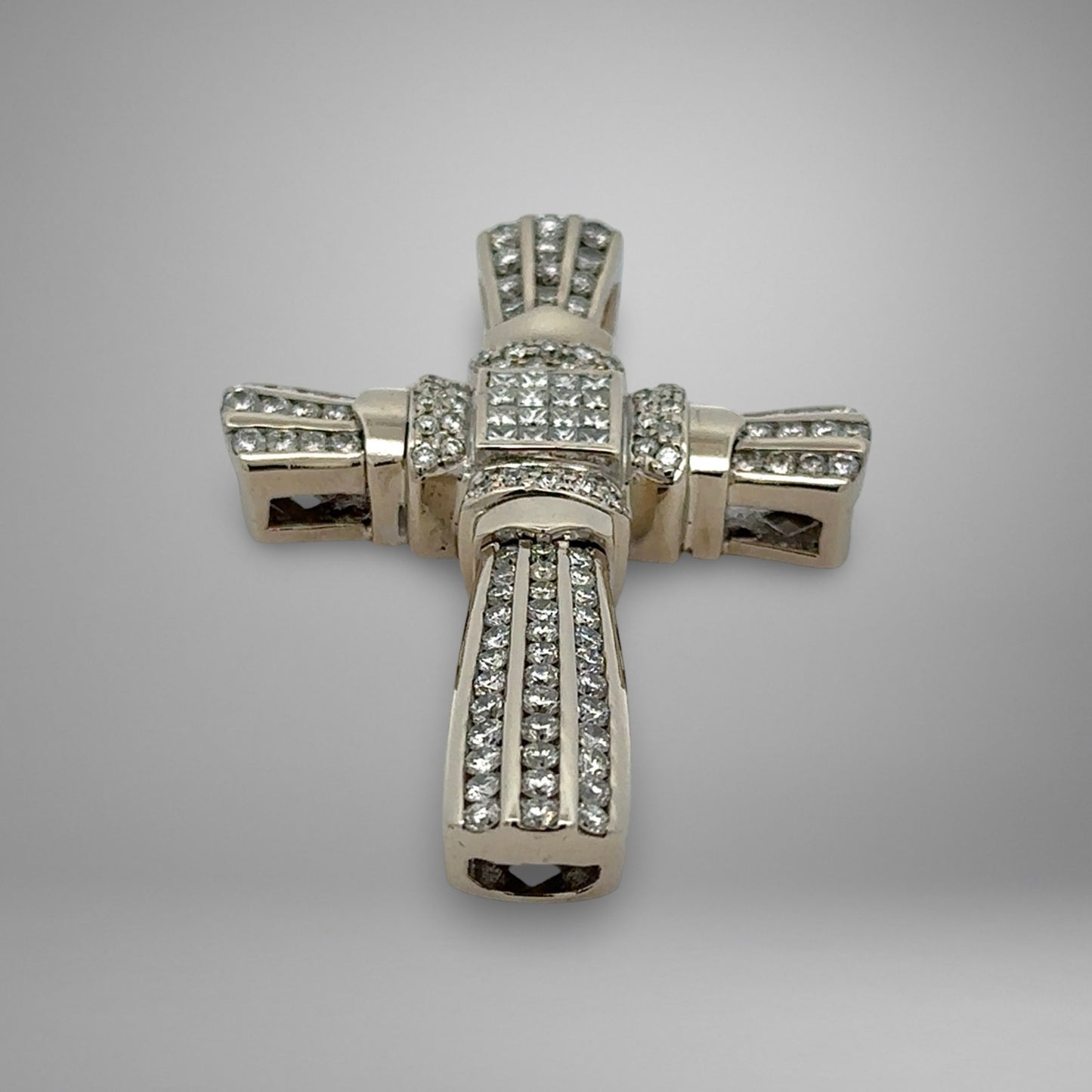 White gold cross pendant with diamonds on a gray background