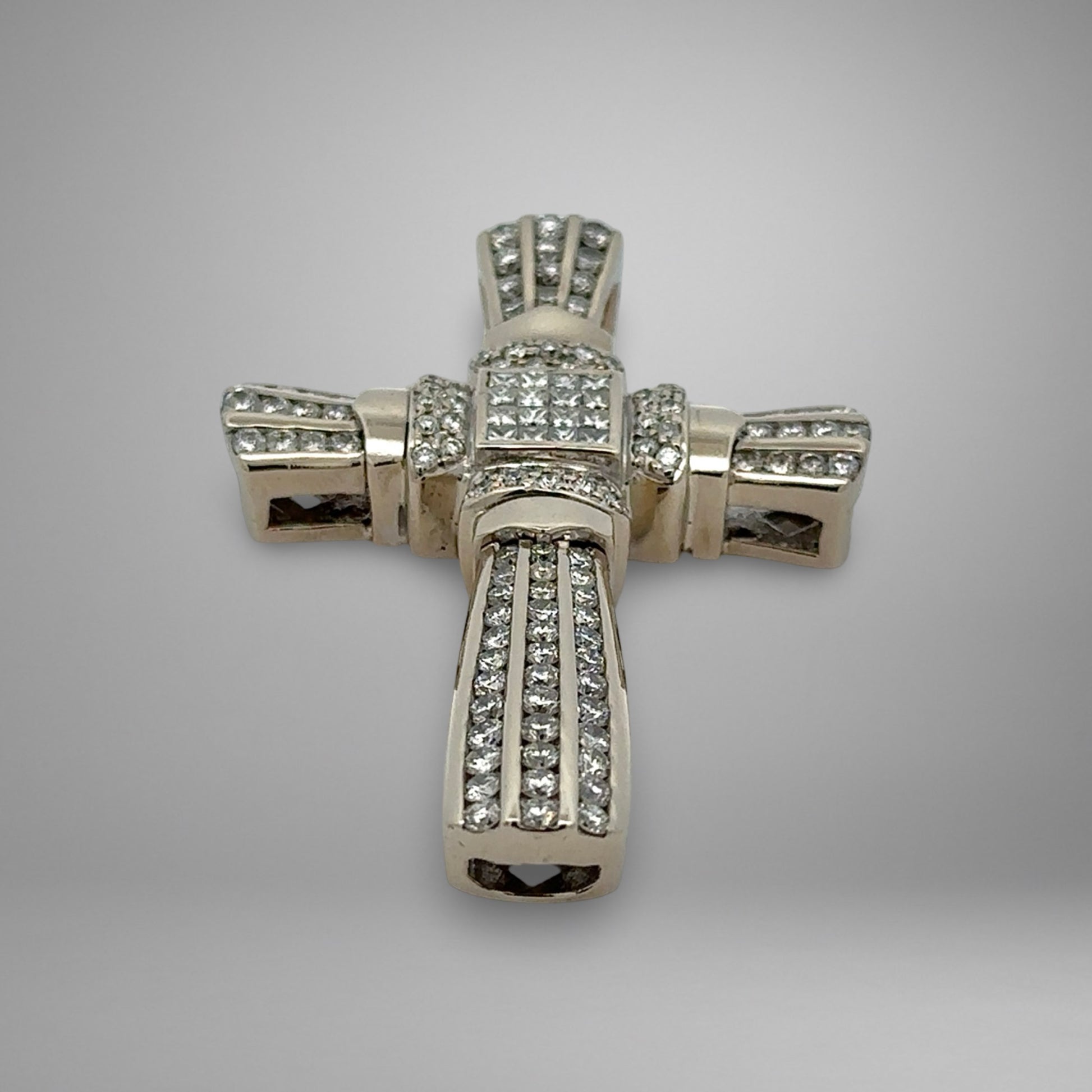 White gold cross pendant with diamonds on a gray background