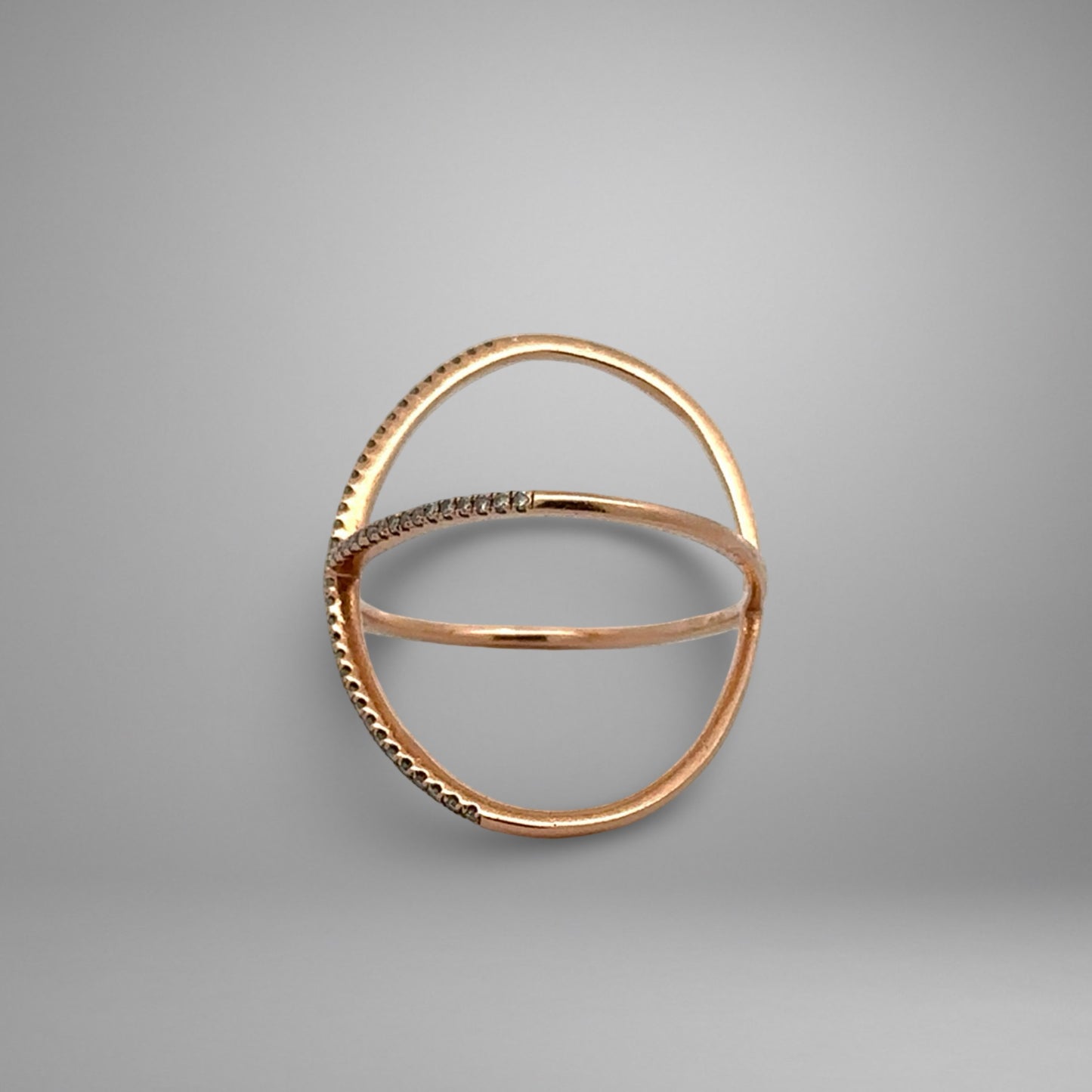 Rose gold ring with small stones on a gray background