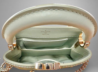 Close-up of a Louis Vuitton handbag with gold hardware on a gray background