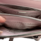 Pictured: One of the top zipper pockets of the Prada Galleria Crystal mini satin bag in pink held open by fingers to see more of the inside. No imperfections..