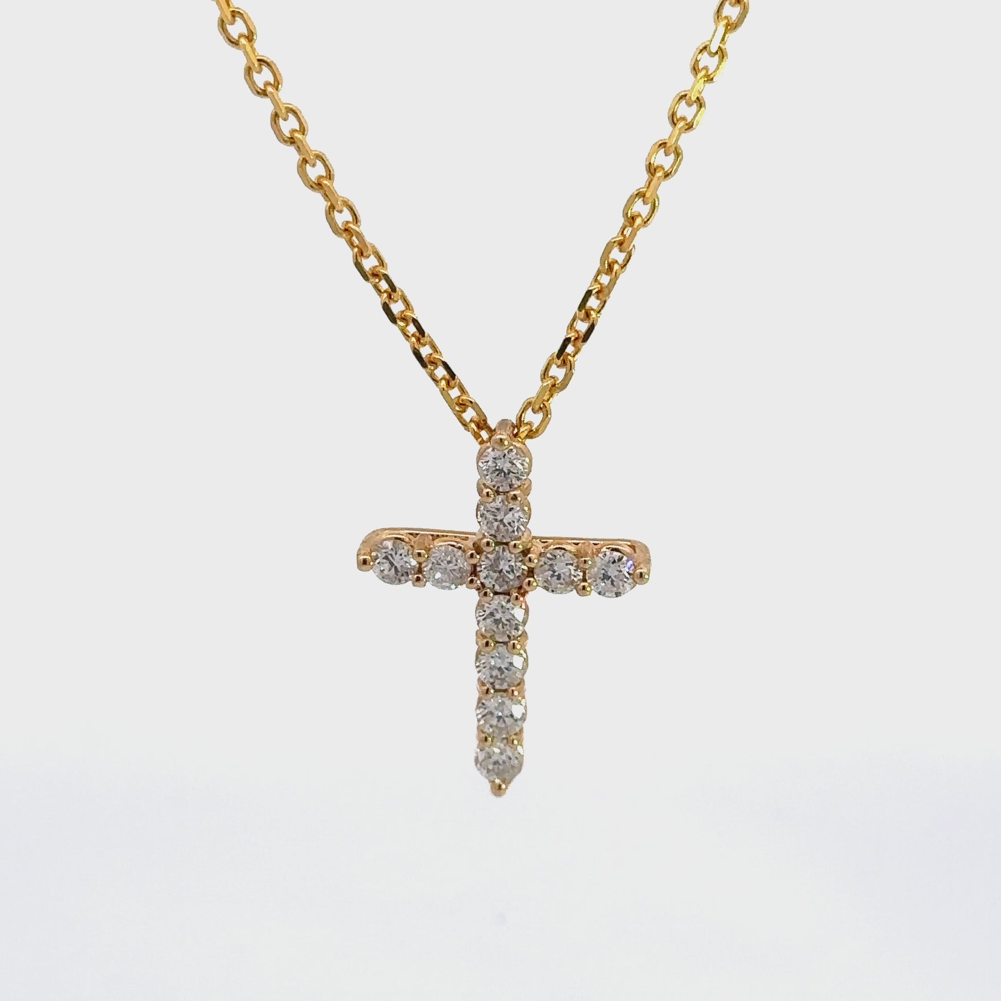 360 Video of Diamond Cross necklace with a thin yellow gold link chain and 11 round diamonds on cross.
